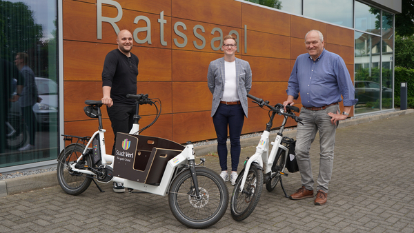 Lauritz Kanne, Dennis Banze und Meinolf Maasmeier mit Fahrrädern vor dem Ratssaal
