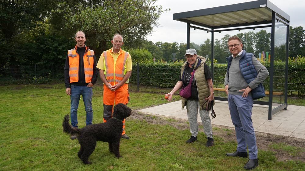 Personengruppe mit Hund vor dem Unterstand
