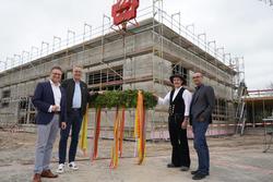 Beim Richtfest: (v. l.) Bürgermeister Robin Rieksneuwöhner, Erster Beigeordneter Thorsten Herbst, Zimmermann Jascha Foster und Thomas Kalmann (Architekturbüro Krieger).