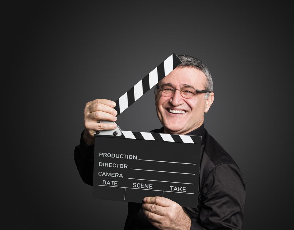 Älterer Mann hält eine Filmklappe