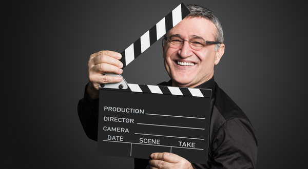 Älterer Mann hält eine Filmklappe