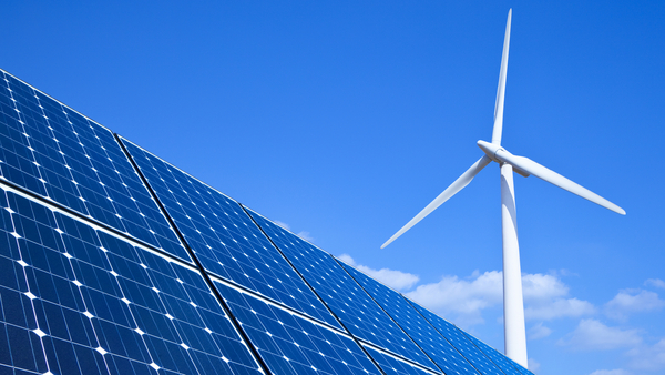 PV-Anlage und Windrad vor blauem Himmel