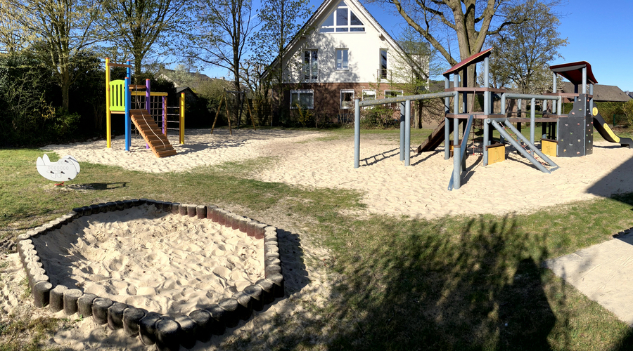 Blick auf Sandkasten, Kletteranlage und Kombi-Spielanlage
