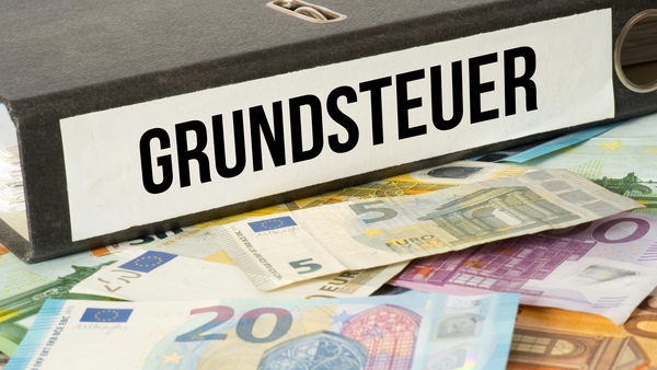 Aktenordner "Grundsteuer" und Geldscheine
