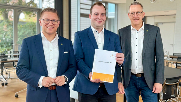 Robin Rieksneuwöhner, Christian Pelkmann und Thorsen Herbst mit dem Etatentwurf im Ratssaal