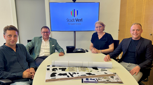 Gruppenbild am Tisch mit Plänen