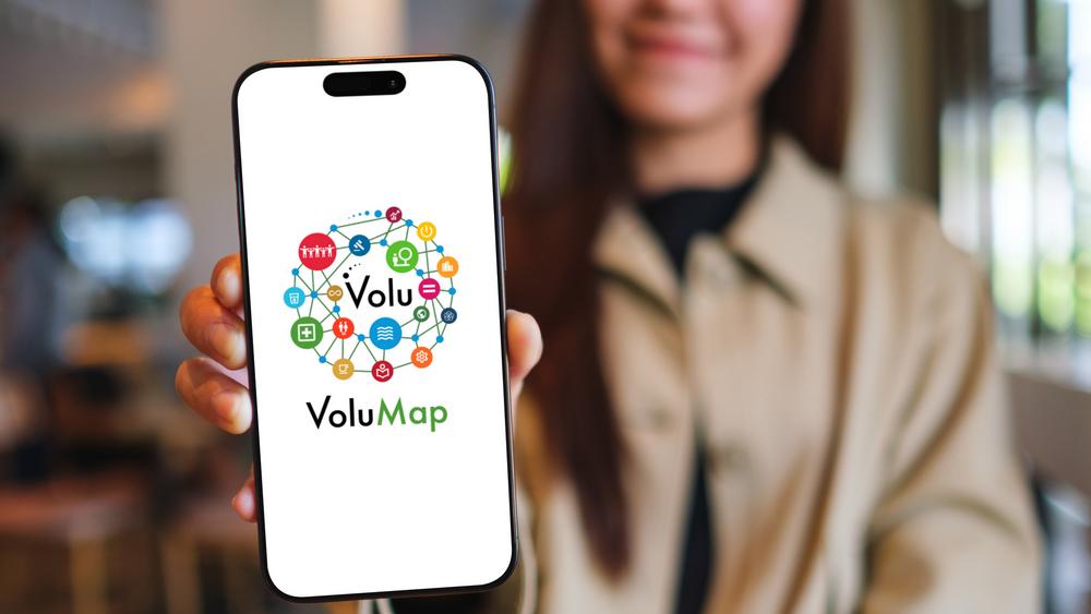 Frau hält Handy mit App VoluMap in die Kamera Frau hält Handy mit App VoluMap in die Kamera